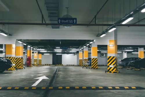 Moderne, goed onderhouden parkeergarage met beschikbare parkeerplaatsen, symbool voor veilige vastgoedinvesteringen in garages.