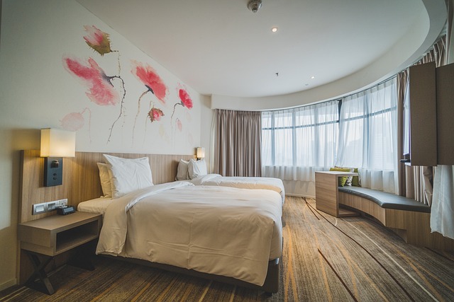 Een moderne hotelkamer met twee eenpersoonsbedden, grote ramen en een artistiek muurschildering van bloemen.